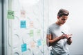 ÃÂ¡oncentrated male project managers using glass wall with sticky notes